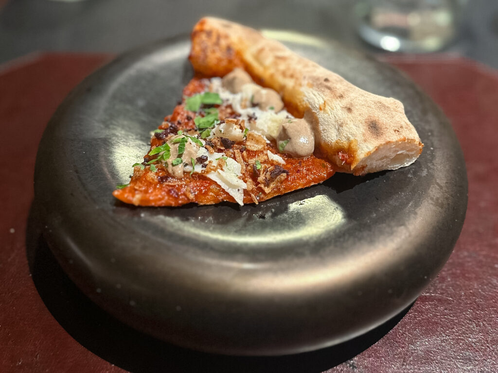 Viking: Crema di pomodoro ciliegino arrosto, baccalà, cipolla croccante, prezzemolo, polvere di oliva caiazzana, mousse di aglio nero fermentato, olio extravergine d'oliva Rotondella.
