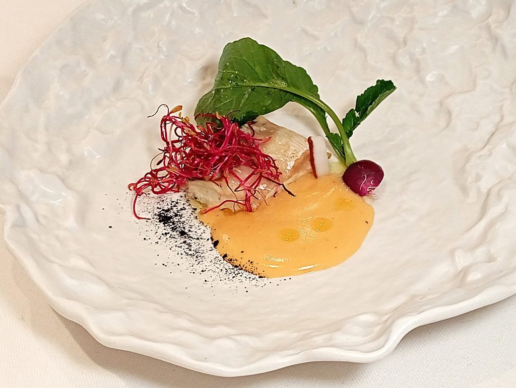 Spigola, salsa di acqua pazza. Ravanello, polvere di aglio nero fermentato