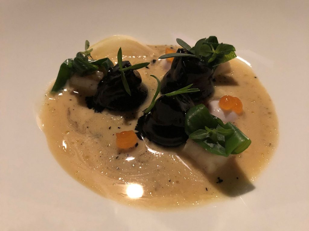 Bottoni ripieni di crema pinoli tostati e calamaretti spillo, cardoncello nappato con nero di seppia, pompelmo, salsa di pesci scoglio e salvia