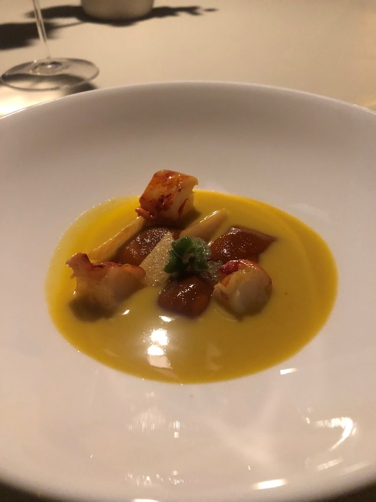 Tortelli di peperoni cotti alla brace, essiccati e frullati, astice alla brace, salsa di pomodorino giallo e vongole.